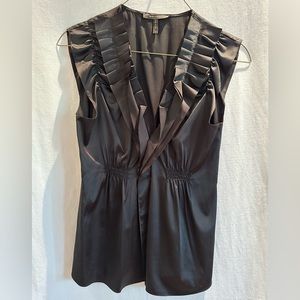 BCBG Sleeveless Satin like blouse. Black with ruffle v-neck detail.